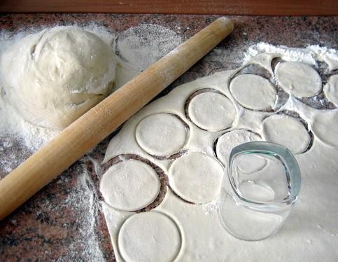 Тесто можно раскатать в пласт, из которого с помощью какой-нибудь круглой формы (например, обычного бокала) вырезать заготовки под вареники